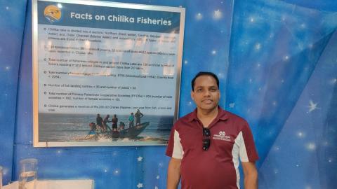 Dr. Dash standing beside research facts board.