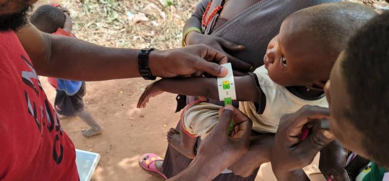 Researcher measuring baby's arm.